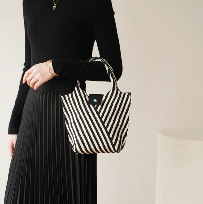 Model carrying a black Vintage Striped Knitted Handbag, great for daily carry and travel.