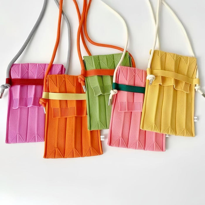 Front view of Five vivid knit polyester mini bags in pink, orange, green, and yellow with adjustable crossbody straps.