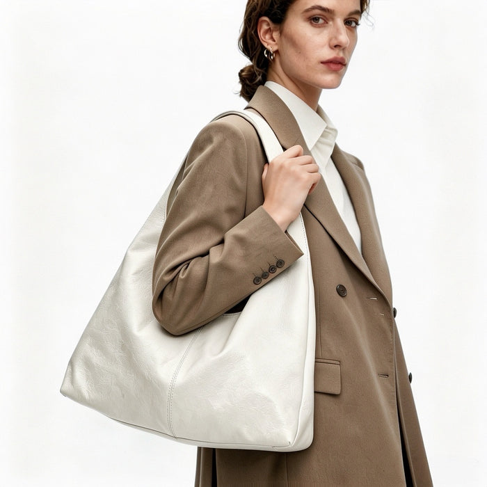 Model wearing the white waxed leather hobo bag on shoulder, showcasing a minimalist style.