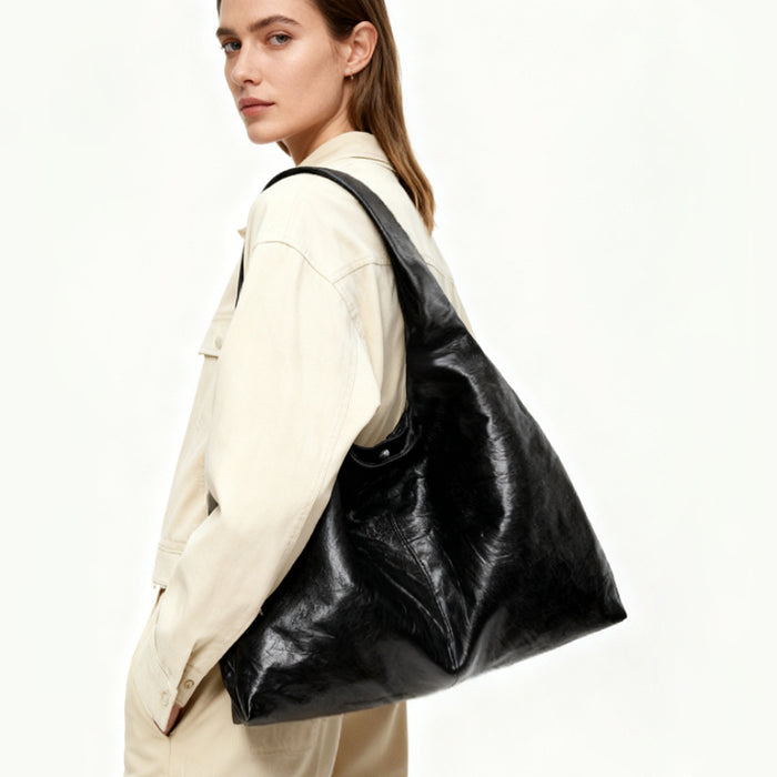 Model styling the black hobo bag with a minimalist outfit.