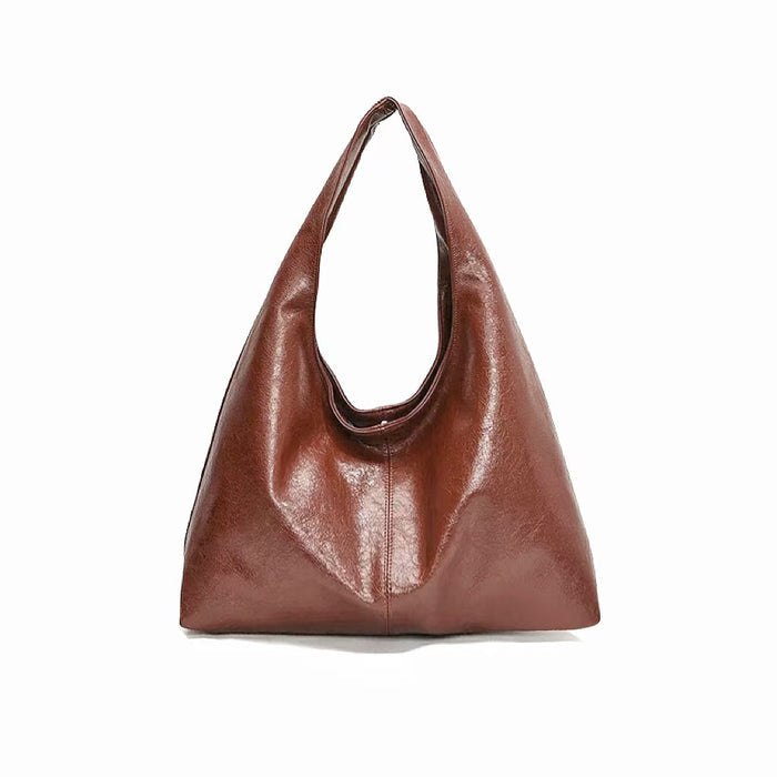 Caramel waxed leather shoulder bag on a white background