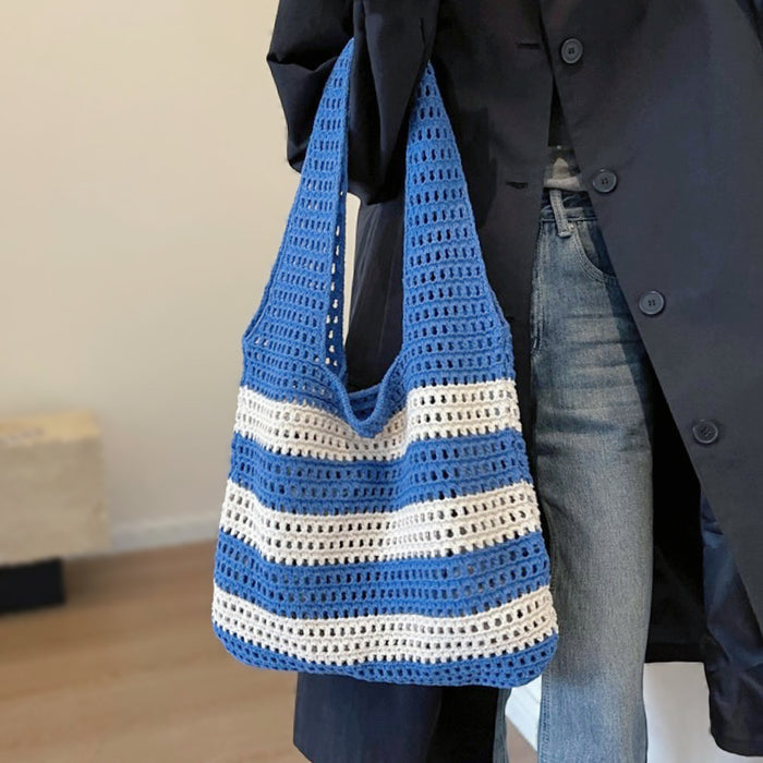 Model carrying a  Wide Stripe Crochet Bag in blue handheld, great for everyday carry and travel.