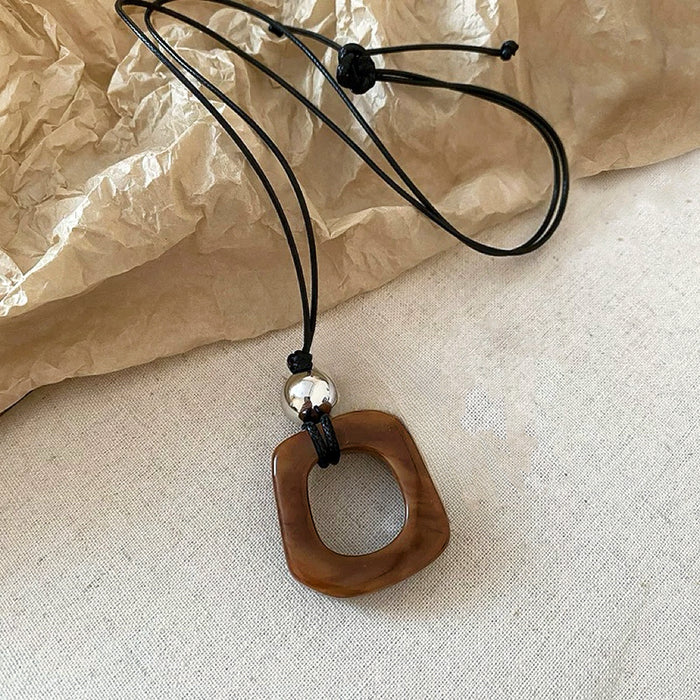 Close-up of Wild Grace Geometric Pendant Necklace in Brown, easy to style.