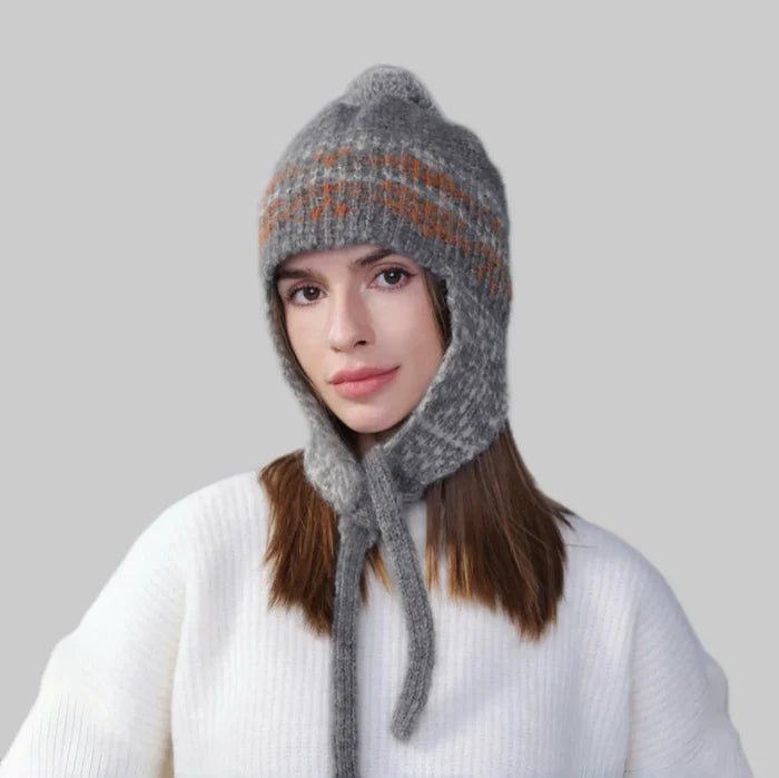 Model wearing grey Winter Isle Ear Flap Hat, features intricate patterns in high-density wool-acrylic blend.