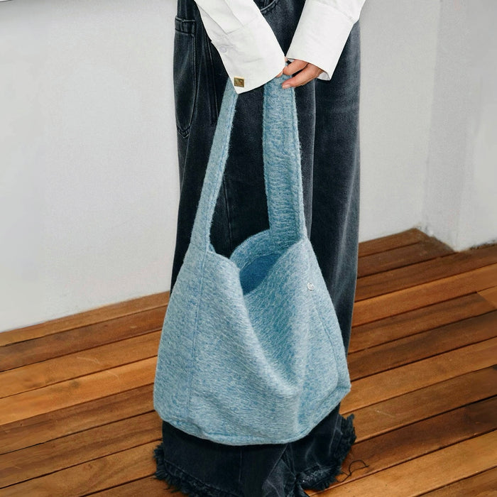 Model carrying a Woolish Cozy Tote Bag in blue handheld, easy for commuting and weekends.