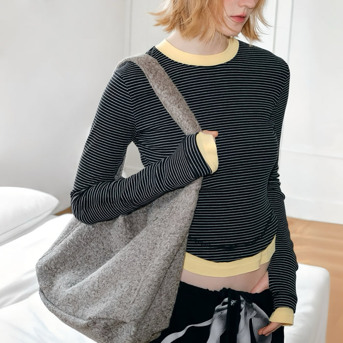 Model carrying a gray  tote bag as shoulder bag, ideal for daily carry and travel.