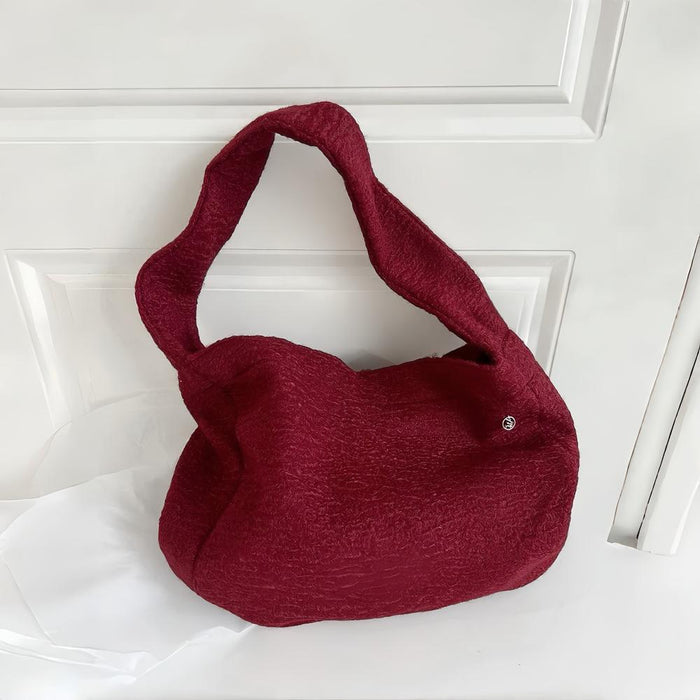 Angled view of Woolish Cozy Tote Bag in red, great for everyday carry and travel.