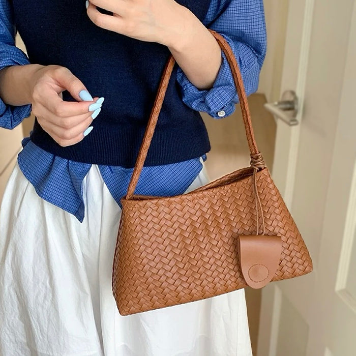 Model carrying a tan bag handheld, easy for commuting and weekends.