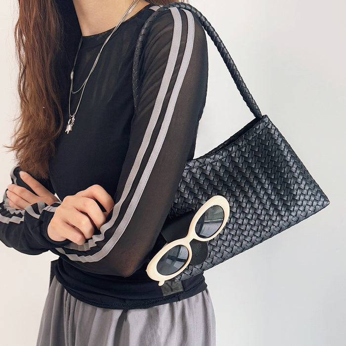 Model carrying a black bag on shoulder , ideal for city walks and gifting.