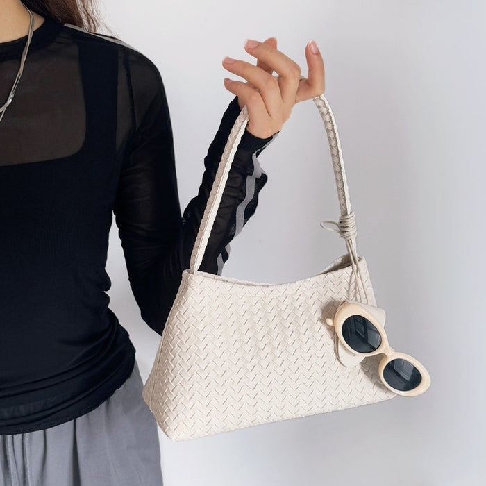 Model carrying a white bag handheld, great for daily carry and travel.