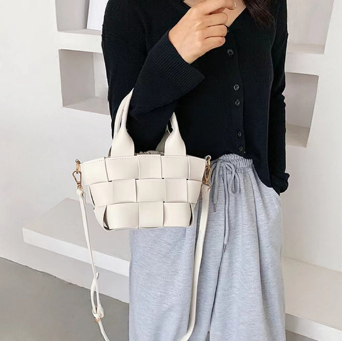 Model carrying a white Woven Leather Mini Basket Bag handheld, ideal for city walks and gifting.