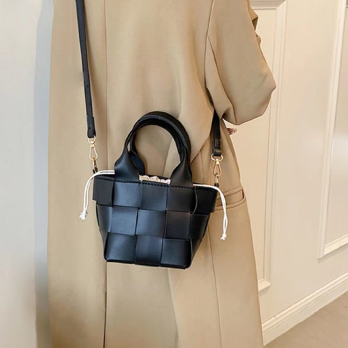 Model carrying a black Woven Leather Mini Basket Bag as crossbody, ideal for errands and gifting.