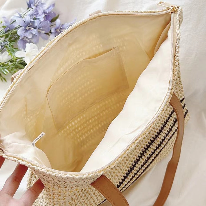 Angled view of Beige woven straw tote bag with brown PU leather straps and a zippered top.