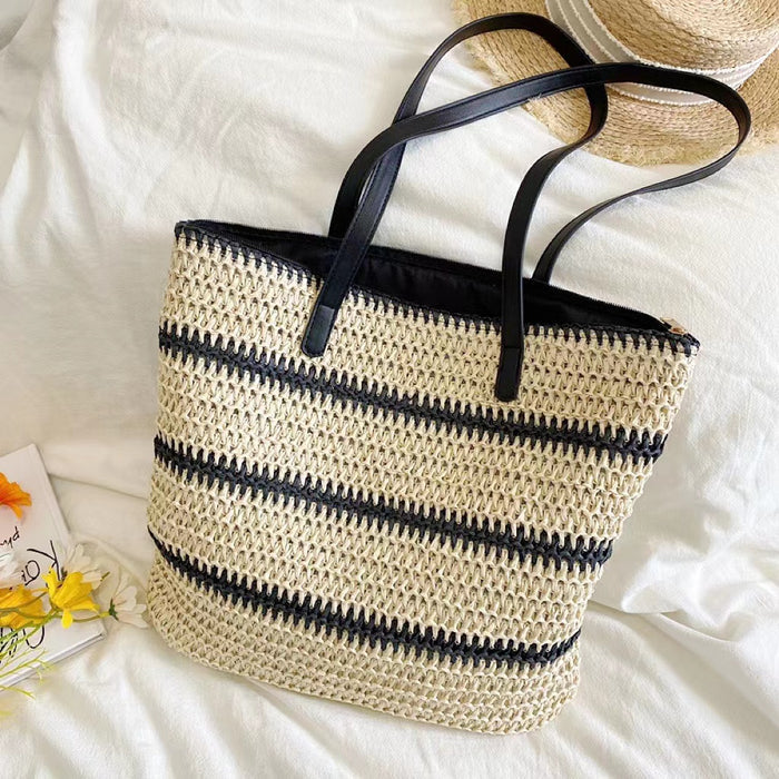 Front view of Woven straw tote bag with black stripes, black PU leather handles, and a zipper closure.