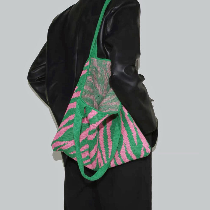 Model carrying a Zebra Print Knitted Tote Bag in green pink, great for daily carry and travel.