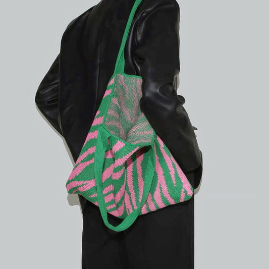 Model carrying a Zebra Print Knitted Tote Bag in green pink, great for daily carry and travel.