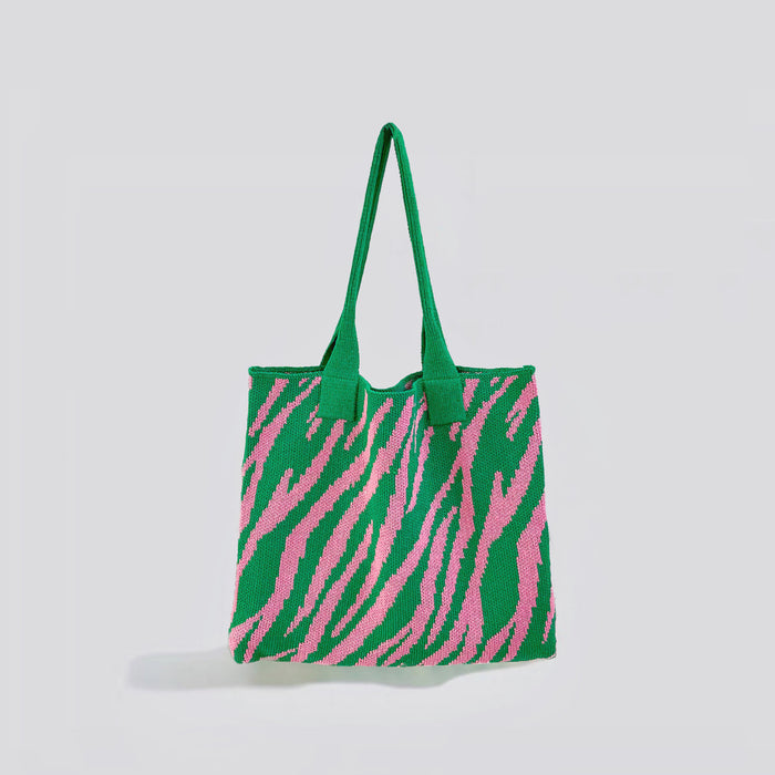 Angled view of  green and pink zebra print knitted tote bag made from blended yarn, easy for commuting and weekends.