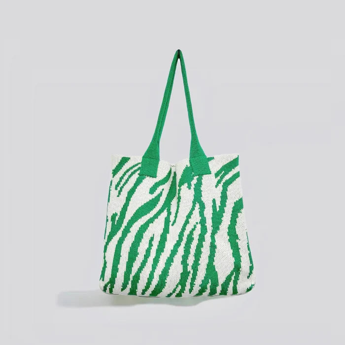 Flat lay of Zebra Print Knitted Tote Bag in white and green, great for everyday carry and travel.