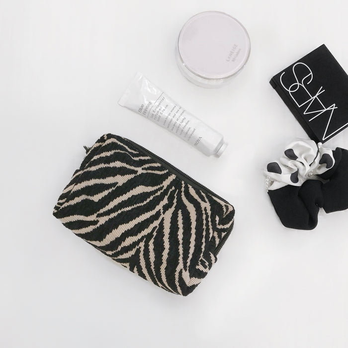 Flat lay of Zebra Print Makeup Bag in black, ideal for travel makeup and toiletries.