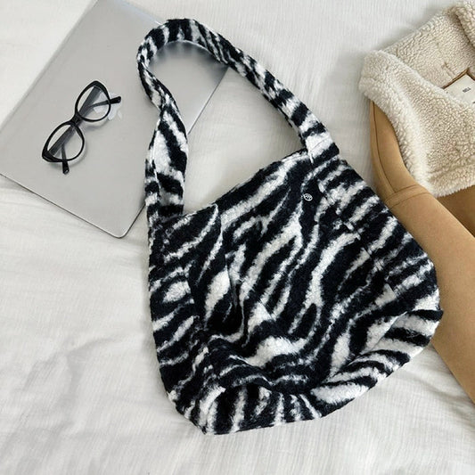 Black and white zebra print polyester tweed tote bag with magnetic clasp.