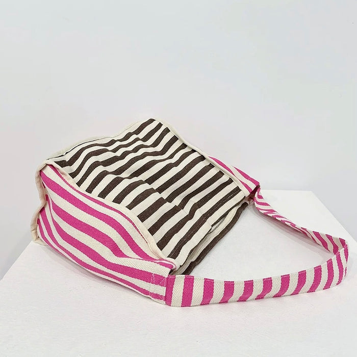 Close-up of Zesty Stripe Canvas Tote Bag with brown and white striped body, and pink and white striped strap.