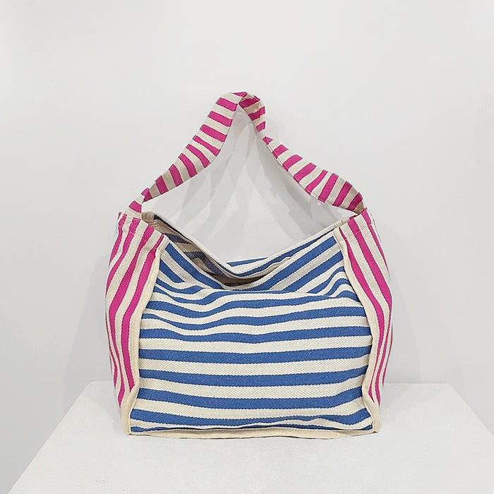 Folded view of Zesty Stripe Canvas Tote Bag in blue, easy for commuting and weekends.